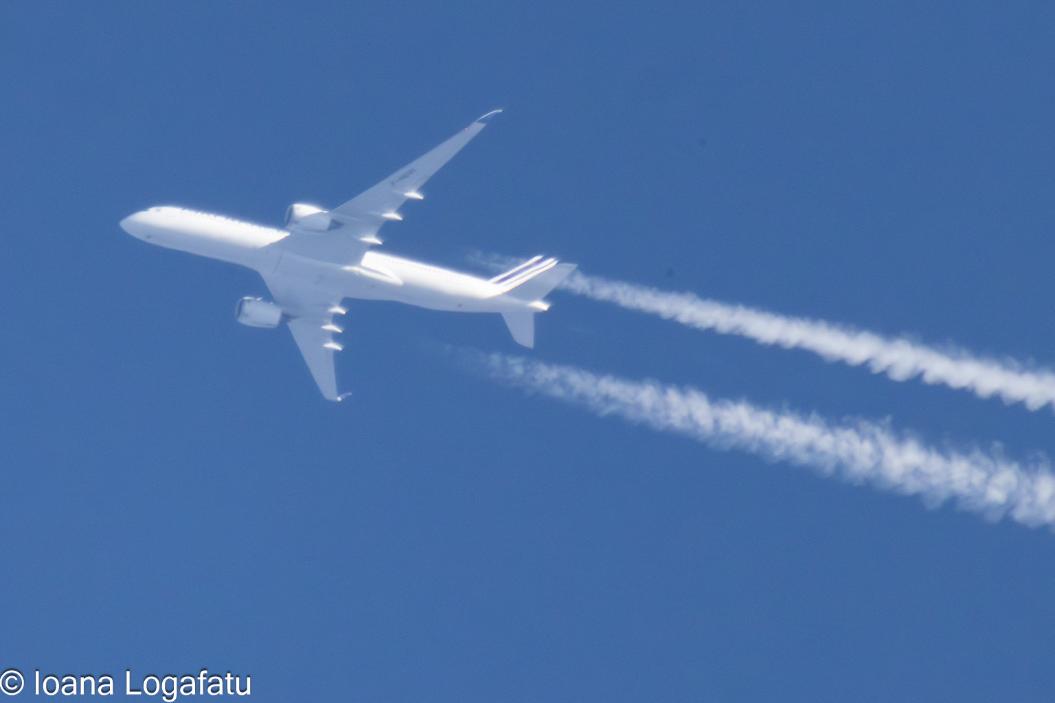 Jet gliding through a clear blue sky above
